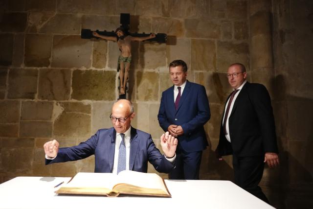 31 August 2026, Saxony-Anhalt, Quedlinburg: German Chancellor Friedrich Merz signs the city's Golden Book in front of Sven Schulze, Minister-President of Saxony-Anhalt and lead candidate of the Christian Democratic Union (CDU), during a visit to Quedlinburg as part of the campaign leading up to the state election in Saxony-Anhalt. Photo: Kay Nietfeld/dpa-Pool/dpa