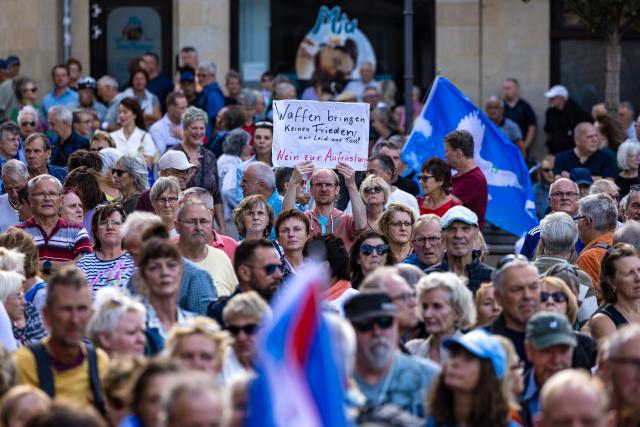 31 August 2026, Brandenburg, Cottbus: A demonstrator holds a sign reading "Weapons do not bring peace; only suffering and death! No to rearmament!" during a peace rally organized by Brandenburg Small Business Initiative. Photo: Frank Hammerschmidt/dpa