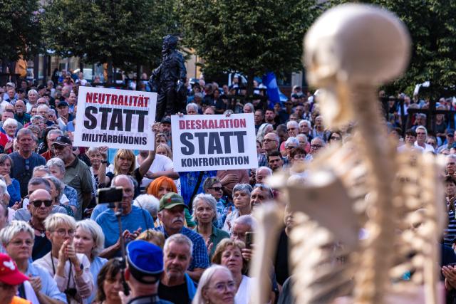 31 August 2026, Brandenburg, Cottbus: Demonstrators hold signs reading "Neutrality instead of military alliances" and "De-escalation instead of confrontation" during a peace rally organized by Brandenburg Small Business Initiative. Photo: Frank Hammerschmidt/dpa