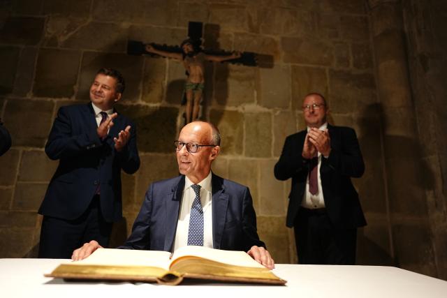 31 August 2026, Saxony-Anhalt, Quedlinburg: German Chancellor Friedrich Merz signs the city's Golden Book in front of Sven Schulze, Minister-President of Saxony-Anhalt and lead candidate of the Christian Democratic Union (CDU), during a visit to Quedlinburg as part of the campaign leading up to the state election in Saxony-Anhalt. Photo: Kay Nietfeld/dpa-Pool/dpa