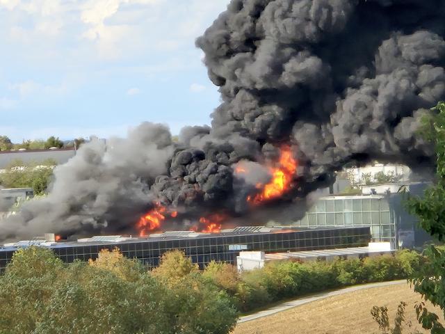 01 September 2026, Bavaria, Wuerzburg: Flames and thick smoke billow from a fire at a trampoline park in Wuerzburg. The park was open when the fire broke out but was not particularly crowded, and everyone had left the building. According to reports, there were no injuries. Photo: Gina Thiel/Mainpost/dpa