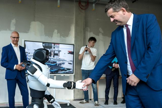 01 September 2026, Saxony-Anhalt, Halle / Saale: Minister-President of Saxony-Anhalt Sven Schulze shakes hands with a humanoid robot at Doegel GmbH's Robo Innovation Lab. The lab, opened in collaboration with the Halle Technology and Startup Center, is the first facility of its kind in central Germany. Photo: Heiko Rebsch/dpa