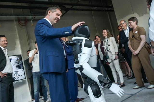 01 September 2026, Saxony-Anhalt, Halle / Saale: Minister-President of Saxony-Anhalt, Sven Schulze examines a humanoid robot at the Robo Innovation Lab of Doegel GmbH. The lab, opened in collaboration with the Halle Technology and Startup Center, is the first facility of its kind in central Germany. Photo: Heiko Rebsch/dpa