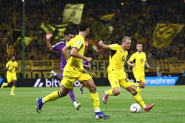 01 September 2026, Hamburg: Borussia Dortmund's Julian Ryerson (r) in action against HEBC's Hammed Nawaz during the German Cup (DFB Pokal) first round soccer match between HEBC and Borussia Dortmund at the Volksparkstadion. Photo: Christian Charisius/dpa - IMPORTANT NOTICE: Bundesliga and DFB regulations prohibit any use of photographs as image sequences and/or quasi-video.