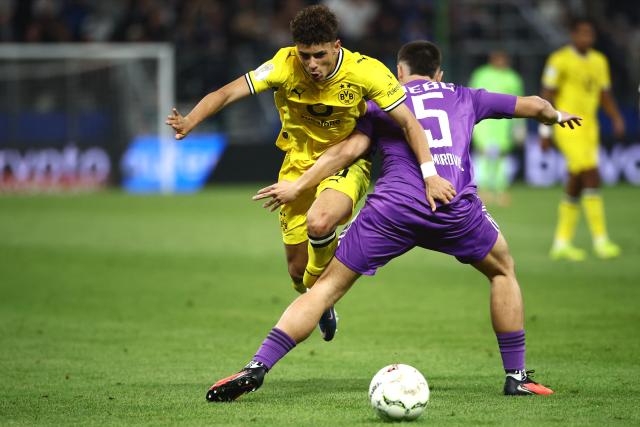 01 September 2026, Hamburg: Borussia Dortmund's Samuele Inacio (L) and HEBC's Semir Demirovic battle for the ball during the German Cup (DFB Pokal) first round soccer match between HEBC and Borussia Dortmund at the Volksparkstadion. Photo: Christian Charisius/dpa - IMPORTANT NOTICE: Bundesliga and DFB regulations prohibit any use of photographs as image sequences and/or quasi-video.