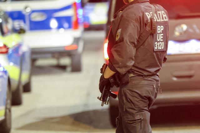 01 September 2026, Hamburg: A police officer armed with a submachine gun stands guard on Lagerstrasse near the exhibition halls, where a spokesperson for the command center reported that a major police operation is underway. Photo: Bodo Marks/dpa