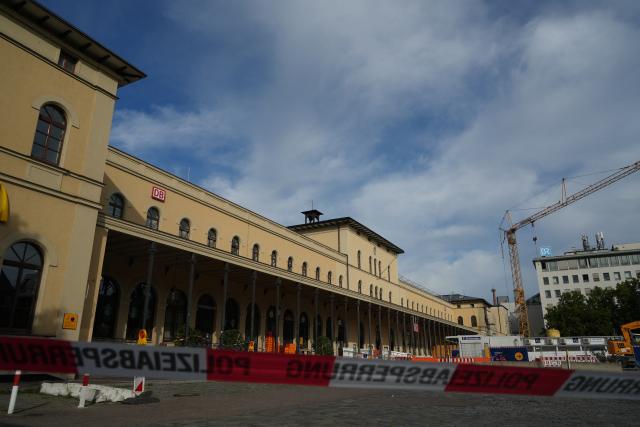 02 September 2026, Bavaria, Augsburg: A Police barrier tape is set up to block access to the main train station in Augsburg, following an explosion near the station, police found a suspicious object. According to police, access to the station is currently completely blocked off, and train service has also been suspended. Photo: Felix Kirberg/dpa