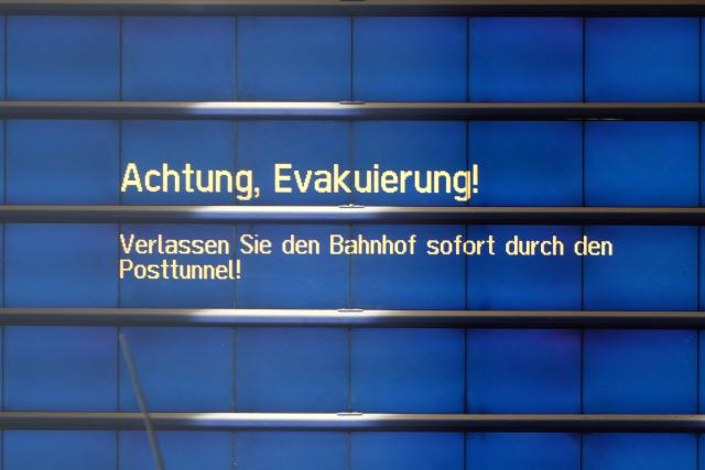 02 September 2026, Bavaria, Augsburg: "Attention: Evacuation! Please leave the station immediately via the Post Tunnel!" is written on a monitor at the the main train station in Augsburg, following an explosion near the station. Police have found a suspicious object. According to police, access to the station is currently completely blocked off, and train service has also been suspended. Photo: Felix Kirberg/dpa
