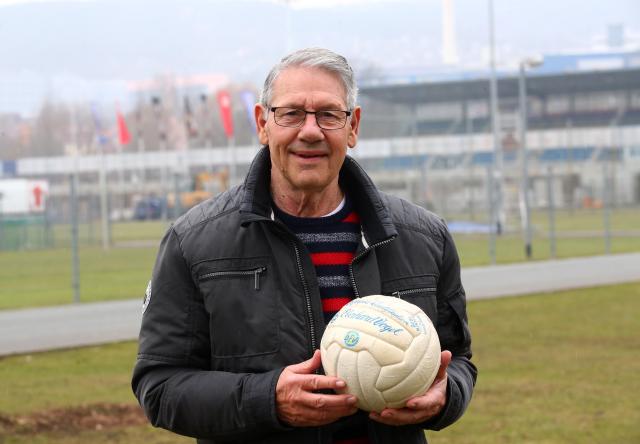 FILED - 26 March 2018, Thuringia, Jena: FILE PHOTO - Former East German national soccer team player Eberhard Vogel, holds the original ball from the 1972 Olympic qualifier on the grounds of the Ernst Abbe Sports Field in Jena. Photo: Bodo Schackow/dpa-Zentralbild/dpa
