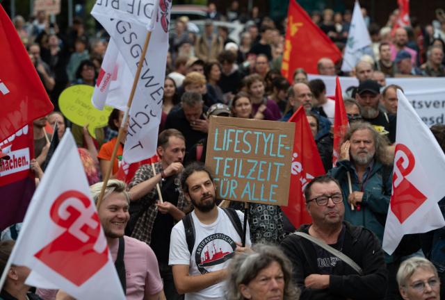 03 September 2026, Saxony, Dresden: At a demonstration against cuts to social services, education, public transportation, and culture, a man holds up a sign that reads "Lifestyle Part-Time Work for Everyone." The Alliance Against Cuts, together with labor unions and the party Die Linke, had called for the protest. Photo: Katharina Kausche/dpa