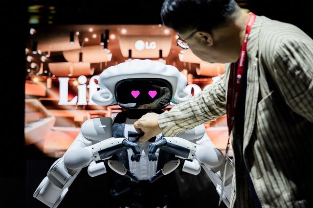 03 September 2026, Berlin: A man adjusts the bow tie of a robot dressed as a conductor, which is on display as part of a tech performance on the second press day of the IFA 2026 electronics trade show in the hall of a South Korean technology conglomerate. IFA 2026 will take place from Friday, September 4, 2026, through Tuesday, September 8, 2026. Photo: Christoph Soeder/dpa