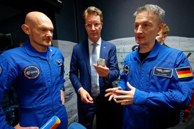 03 September 2026, North Rhine-Westphalia, Cologne: Astronauts Matthias Maurer (R) and Alexander Gerst (L), along with North Rhine-Hendrik Wüst (CDU), Minister President of North Rhine-Westphalia, examine a block of sintered lunar dust that can be used as a building material during a visit to the new FLEXhab and the LUNA lunar simulation facility at the German Aerospace Center (DLR) and the European Space Agency (ESA). Photo: Henning Kaiser/dpa