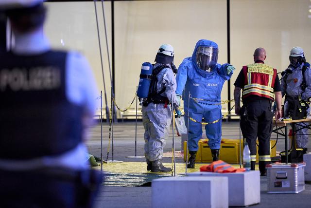 03 September 2026, Brandenburg, Schönefeld: A firefighter wearing a chemical protection suit is being decontaminated by a colleague outside Terminal 1 at BER Airport, which was partially evacuated due to a potentially hazardous substance. Photo: Michael Ukas/dpa