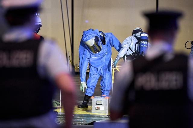 03 September 2026, Brandenburg, Schönefeld: A firefighter wearing a chemical protection suit is being decontaminated by a colleague outside Terminal 1 at BER Airport, which was partially evacuated due to a potentially hazardous substance. Photo: Michael Ukas/dpa