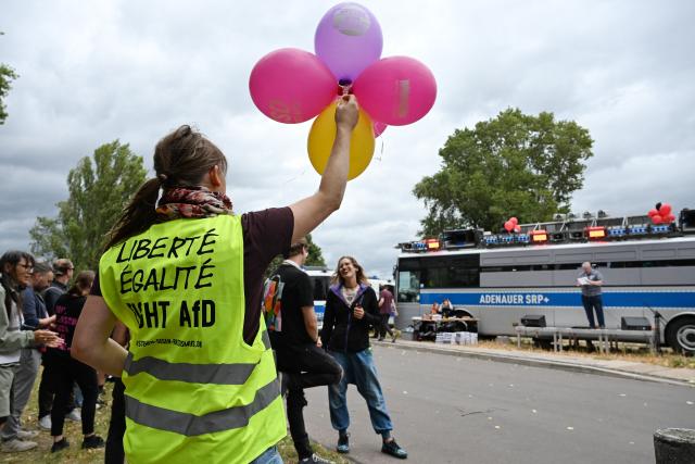 04 September 2026, Saxony-Anhalt, Magdeburg: Protesters hold balloons and signs near a planned Alternative for Germany (AfD) event in Magdeburg. Photo: Michael Brandt/dpa