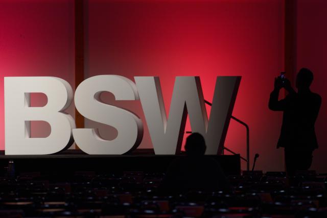 FILED - 06 December 2025, Saxony-Anhalt, Magdeburg: FILE PHOTO - A participant stands in front of large BSW logo during the 3rd Federal Party Conference of the Sahra Wagenknecht Alliance (BSW). Photo: Klaus-Dietmar Gabbert/dpa