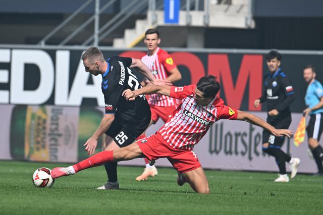05 September 2026, North Rhine-Westphalia, Paderborn: Paderborn's Tjark Scheller (L) and Freiburg's Igor Matanovic battle for the ball during the German Bundesliga soccer match between SC Paderborn 07 and SC Freiburg at the Home Deluxe Arena. Photo: Swen Pförtner/dpa - IMPORTANT NOTICE: Bundesliga and DFB regulations prohibit any use of photographs as image sequences and/or quasi-video.