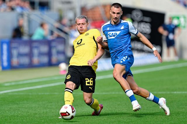 05 September 2026, Baden-Württemberg, Sinsheim: Borussia Dortmund's Julian Ryerson (L) and Hoffenheim's Tim Lemperle battle for the ball during the German Bundesliga soccer match between TSG 1899 Hoffenheim and Borussia Dortmund at the SNP Arena. Photo: Uwe Anspach/dpa - IMPORTANT NOTICE: Bundesliga and DFB regulations prohibit any use of photographs as image sequences and/or quasi-video.