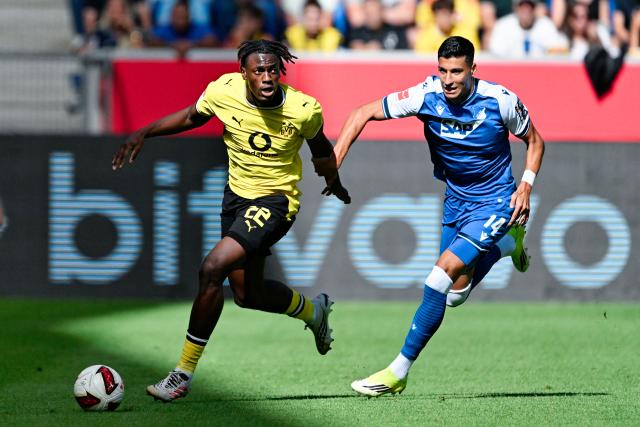 05 September 2026, Baden-Württemberg, Sinsheim: Dortmund's Joane Gadou (L) and Hoffenheim's Adam Daghim battle for the ball during the German Bundesliga soccer match between TSG 1899 Hoffenheim and Borussia Dortmund at the SNP Arena. Photo: Uwe Anspach/dpa - IMPORTANT NOTICE: Bundesliga and DFB regulations prohibit any use of photographs as image sequences and/or quasi-video.