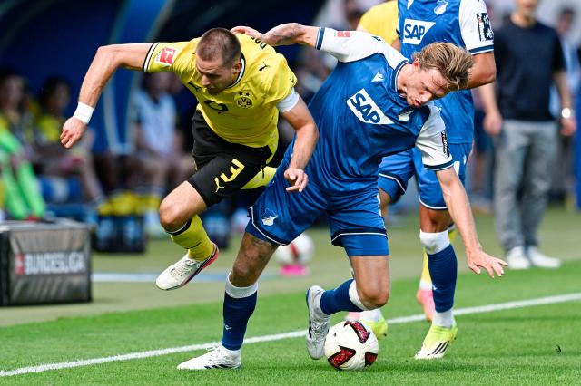 05 September 2026, Baden-Württemberg, Sinsheim: Borussia Dortmund's Waldemar Anton and Hoffenheim's Wouter Burger battle for the ball during the German Bundesliga soccer match between TSG 1899 Hoffenheim and Borussia Dortmund at the SNP Arena. Photo: Uwe Anspach/dpa - IMPORTANT NOTICE: Bundesliga and DFB regulations prohibit any use of photographs as image sequences and/or quasi-video.