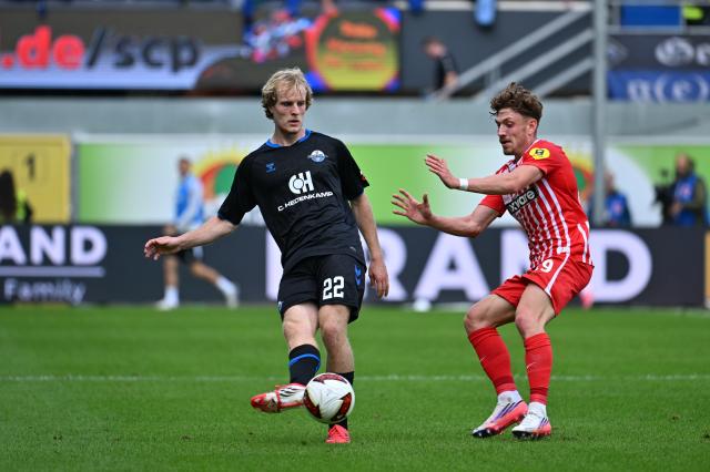 05 September 2026, North Rhine-Westphalia, Paderborn: Paderborn's Mattes Hansen (L) and Freiburg's Philipp Treu battle for the ball during the German Bundesliga soccer match between SC Paderborn 07 and SC Freiburg at the Home Deluxe Arena. Photo: Swen Pförtner/dpa - IMPORTANT NOTICE: Bundesliga and DFB regulations prohibit any use of photographs as image sequences and/or quasi-video.