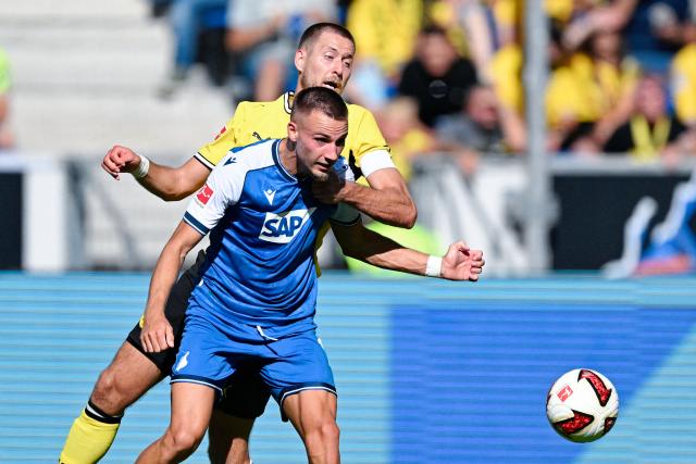 05 September 2026, Baden-Württemberg, Sinsheim: Hoffenheim's Tim Lemperle and Borussia Dortmund's Waldemar Anton battle for the ball during the German Bundesliga soccer match between TSG 1899 Hoffenheim and Borussia Dortmund at the SNP Arena. Photo: Uwe Anspach/dpa - IMPORTANT NOTICE: Bundesliga and DFB regulations prohibit any use of photographs as image sequences and/or quasi-video.