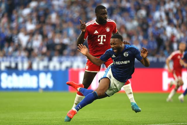 05 September 2026, North Rhine-Westphalia, Gelsenkirchen: Schalke's Moussa Sylla (front) is fouled by Bayern Munich's Dayot Upamecano during the German Bundesliga soccer match between FC Schalke 04 and Bayern Munich at the Veltins Arena. Photo: Fabian Strauch/dpa - IMPORTANT NOTICE: Bundesliga and DFB regulations prohibit any use of photographs as image sequences and/or quasi-video.