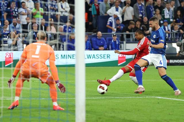 05 September 2026, North Rhine-Westphalia, Gelsenkirchen: Bayern Munich's Michael Olise (C) shoots at Schalke goalkeeper Loris Karius during the German Bundesliga soccer match between FC Schalke 04 and Bayern Munich at the Veltins Arena. Photo: Fabian Strauch/dpa - IMPORTANT NOTICE: Bundesliga and DFB regulations prohibit any use of photographs as image sequences and/or quasi-video.