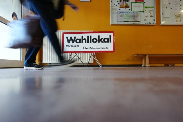 06 September 2026, Saxony-Anhalt, Tangermünde: Early in the morning, an election worker walks past a sign reading "Polling Place" at a polling station in Tangermuende. Saxony-Anhalt elects a new state parliament on Sunday. Photo: Kay Nietfeld/dpa