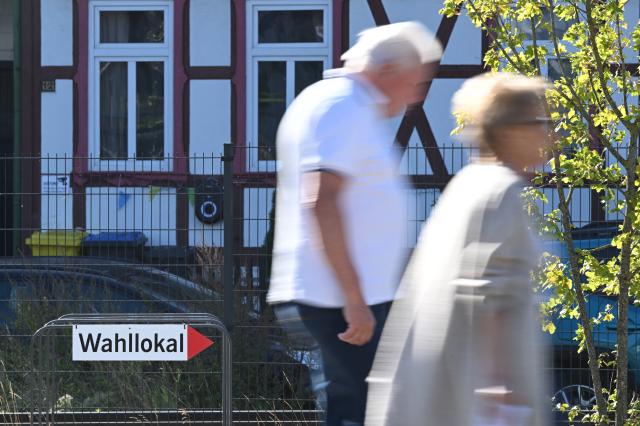 06 September 2026, Saxony-Anhalt, Wernigerode: Voters walk past a sign pointing to the polling station where SPD lead candidate Willingmann will cast his vote in the state election. Saxony-Anhalt elects a new state parliament on Sunday. Photo: Julian Stratenschulte/dpa