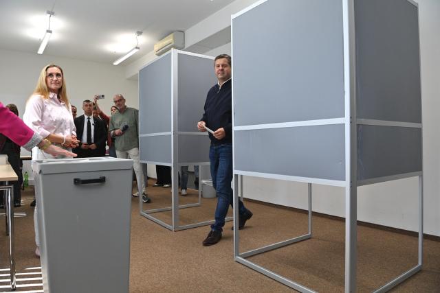 06 September 2026, Saxony-Anhalt, Magdeburg: Sven Schulze, Minister-President of Saxony-Anhalt and state chairman of the CDU in Saxony-Anhalt, emerges from a voting booth holding his folded ballot. His wife, Kati Schulze, stands beside the ballot box. Saxony-Anhalt elects a new state parliament on Sunday. Photo: Klaus-Dietmar Gabbert/dpa