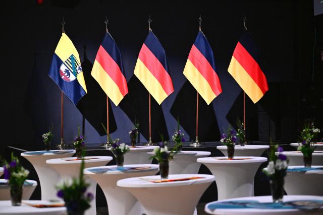 06 September 2026, Saxony-Anhalt, Magdeburg: German flags and the state flag of Saxony-Anhalt (L) are displayed on the podium in front of the Alternative for Germany (AfD) election party at the Altes Theater. A new state parliament will be elected in Saxony-Anhalt on Sunday. Photo: Sebastian Gollnow/dpa