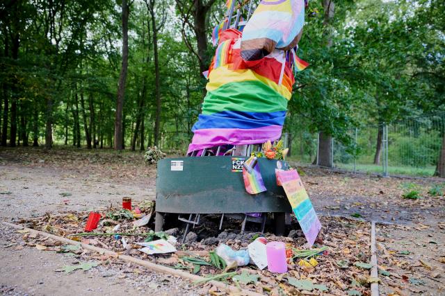 06 September 2026, Berlin: Flowers, candles, and a handwritten message in rainbow colors have been placed at the damaged memorial tree in Berlin's Tiergarten, dedicated to the victims of the Christopher Street Day
(CSD) attack. Photo: Annette Riedl/dpa