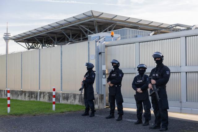 07 September 2026, North Rhine-Westphalia, Duesseldorf: Heavily armed police officers stand in front of the high-security wing of the Higher Regional Court, where the trial of a man accused of attempting to murder a drug lord's nephew begins. On 30 December 2025, two men reportedly jumped out of a car and fired ten shots at a passenger in a taxi on a major thoroughfare in Düsseldorf. Photo: Rolf Vennenbernd/dpa