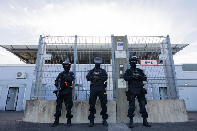 07 September 2026, North Rhine-Westphalia, Duesseldorf: Heavily armed police officers stand in front of the high-security wing of the Higher Regional Court, where the trial of a man accused of attempting to murder a drug lord's nephew begins. On 30 December 2025, two men reportedly jumped out of a car and fired ten shots at a passenger in a taxi on a major thoroughfare in Düsseldorf. Photo: Rolf Vennenbernd/dpa