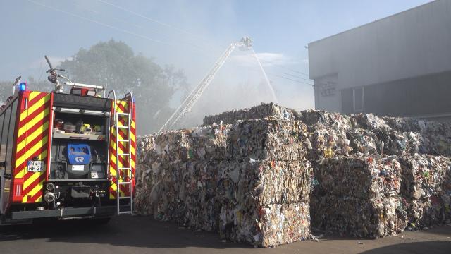 07 September 2026, Rhineland-Palatinate, Boden: Firefighters battle a fire burning in front of a warehouse at a waste management facility. Photo: Sascha Ditscher/dpa