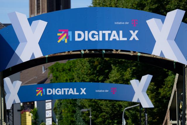 08 September 2026, North Rhine-Westphalia, Cologne: The logo for Deutsche Telekom's Digital X trade show can be seen on a swing bridge at Rheinauhafen. Photo: Henning Kaiser/dpa