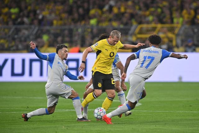 08 September 2026, North Rhine-Westphalia, Dortmund: Borussia Dortmund's Julian Ryerson (C) battles for the ball with Villarreal's Tajon Buchanan (R), Nathan Saliba and Georges Mikautadze (L) during the UEFA Champions League group stage soccer match between Borussia Dortmund and Villarreal CF at Signal Iduna Park. Photo: Bernd Thissen/dpa