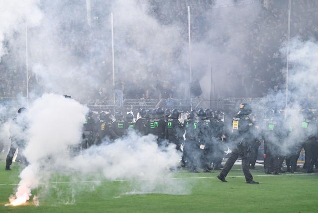 FILED - 22 August 2026, Baden-Württemberg, Mannheim: FILE PHOTO - Police officers stand in front of the SV Waldhof Mannheim fan section during the German DFB Cup first round soccer match between SV Waldhof Mannheim and 1. FC Kaiserslautern at Carl-Benz-Stadion. A German police officer is being investigated over his involvement in a riot at a German Cup first-round game last month. Photo: Uwe Anspach/dpa - IMPORTANT NOTICE: In accordance with the regulations of the Bundesliga and the German Football Association (DFB), it is prohibited to use or allow the use of photographs taken in the stadium and/or during the game in the form of sequential images and/or video-like photo series.