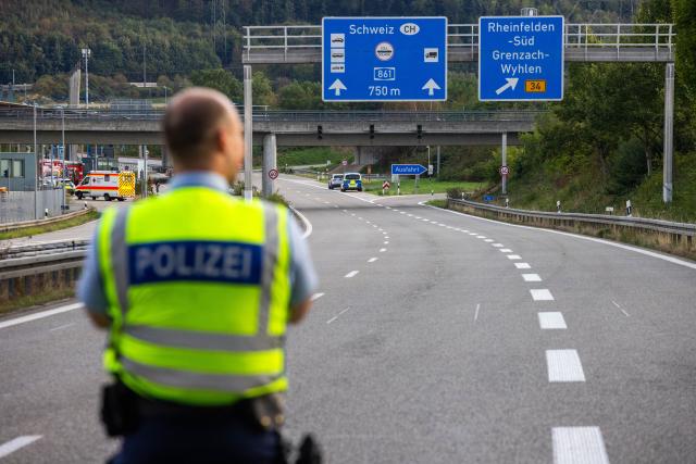 09 September 2026, Baden-Wuerttemberg, Rheinfelden: A police officer stands on the A861 highway near Rheinfelden, with the border crossing into Switzerland visible in the background. Following a suspected discovery of explosives during a vehicle inspection, the border crossing into Switzerland at the Rheinfelden-Autobahn checkpoint has been closed in both directions. Photo: Philipp von Ditfurth/dpa