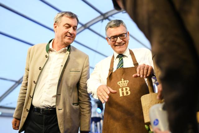 09 September 2026, Berlin: Minister President of Bavaria Markus Soeder (L) looks at the beer keg that Head of the Bavarian State Chancellery and Minister of State for Federal Affairs and Media Florian Herrmann has tapped at the traditional Berlin kickoff of the Munich Oktoberfest at the "Tipi am Kanzleramt". Photo: Annette Riedl/dpa