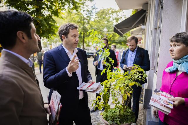 10 September 2026, Berlin: Lars Klingbeil (C), German Minister of Finance, speaks with a small business owner during a Social Democratic Party (SPD) campaign visit that included a tour of the area. Photo: Christoph Soeder/dpa