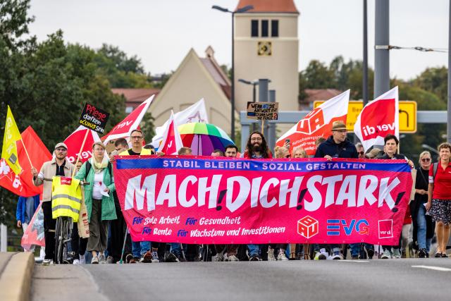 12 September 2026, Brandenburg, Cottbus: Participants in a labour union demonstration march through the city centre behind a banner reading "Be Strong". Members of the ver.di, BAU and EVG labour unions are demonstrating under the slogan "Enough Is Enough" against planned social cuts in Germany. Photo: Frank Hammerschmidt/dpa