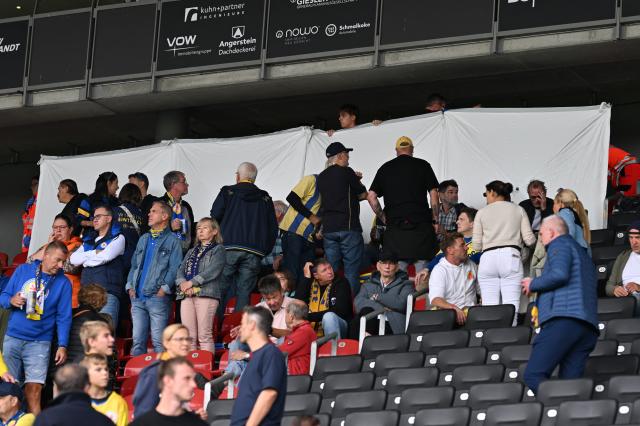 12 September 2026, Lower Saxony, Braunschweig: A white sheet has been stretched out due to an emergency medical response as spectators stand and sit in the stands during the German 2nd Bundesliga soccer match between Eintracht Braunschweig and SG Dynamo Dresden at Eintracht Stadium. Photo: Swen Pförtner/dpa