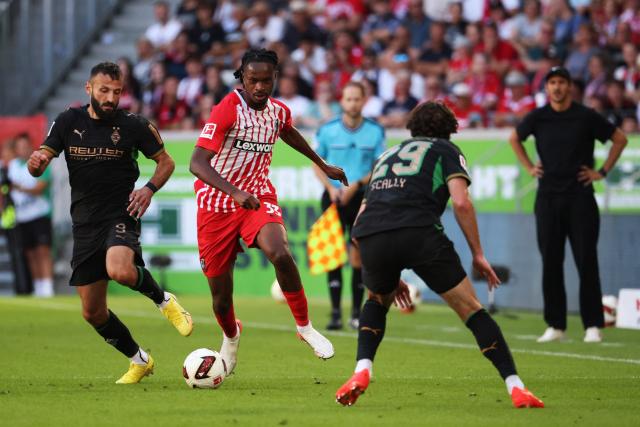12 September 2026, Baden-Wuerttemberg, Freiburg im Breisgau: Freiburg's Jordy Makengo (C) battles for the ball with Moenchengladbach's Franck Honorat (L) and Joe Scally during the German Bundesliga soccer match between SC Freiburg and Borussia Moenchengladbach at Europa-Park Stadium. Photo: Philipp von Ditfurth/dpa - WICHTIGER HINWEIS: Gemäß den Vorgaben der Bundesliga bzw. des DFB Deutscher Fußball-Bund ist es untersagt, in dem Stadion und/oder vom Spiel angefertigte Fotoaufnahmen in Form von Sequenzbildern und/oder videoähnlichen Fotostrecken zu verwerten bzw. verwerten zu lassen.