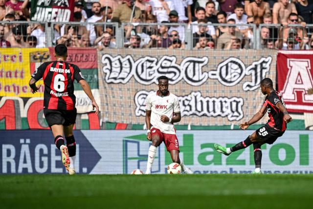 12 September 2026, Bavaria, Augsburg: Bayer Leverkusen's Christian Kofane (R) scores his side's first goal during the German Bundesliga soccer match between FC Augsburg and Bayer Leverkusen at WWK-Arena. Photo: Harry Langer/dpa - WICHTIGER HINWEIS: Gemäß den Vorgaben der Bundesliga bzw. des DFB Deutscher Fußball-Bund ist es untersagt, in dem Stadion und/oder vom Spiel angefertigte Fotoaufnahmen in Form von Sequenzbildern und/oder videoähnlichen Fotostrecken zu verwerten bzw. verwerten zu lassen.