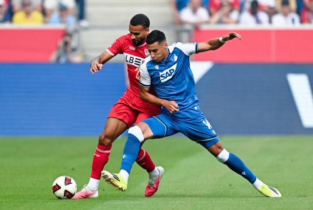 12 September 2026, Baden-Wuerttemberg, Sinsheim: Stuttgart's Josha Vagnoman (L) and Hoffenheim's Adam Daghim battle for the ball during the German Bundesliga soccer match between TSG 1899 Hoffenheim and VfB Stuttgart at SNP Arena. Photo: Uwe Anspach/dpa - WICHTIGER HINWEIS: Gemäß den Vorgaben der Bundesliga bzw. des DFB Deutscher Fußball-Bund ist es untersagt, in dem Stadion und/oder vom Spiel angefertigte Fotoaufnahmen in Form von Sequenzbildern und/oder videoähnlichen Fotostrecken zu verwerten bzw. verwerten zu lassen.
