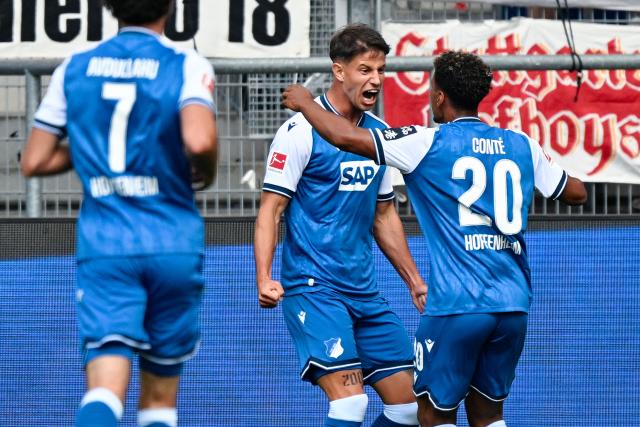 12 September 2026, Baden-Wuerttemberg, Sinsheim: Hoffenheim's Adam Hlozek (C) celebrates scoring his side's first goal with teammates during the German Bundesliga soccer match between TSG 1899 Hoffenheim and VfB Stuttgart at SNP Arena. Photo: Uwe Anspach/dpa - WICHTIGER HINWEIS: Gemäß den Vorgaben der Bundesliga bzw. des DFB Deutscher Fußball-Bund ist es untersagt, in dem Stadion und/oder vom Spiel angefertigte Fotoaufnahmen in Form von Sequenzbildern und/oder videoähnlichen Fotostrecken zu verwerten bzw. verwerten zu lassen.