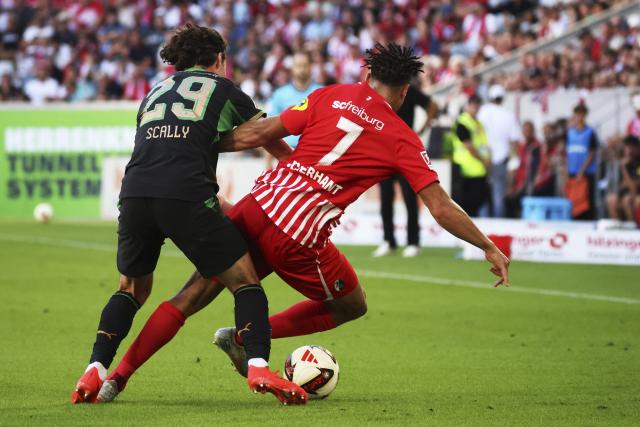 12 September 2026, Baden-Wuerttemberg, Freiburg im Breisgau: Moenchengladbach's Joe Scally (L) brings down Freiburg's Derry Scherhant during the German Bundesliga soccer match between SC Freiburg and Borussia Moenchengladbach at Europa-Park Stadium. Photo: Philipp von Ditfurth/dpa - WICHTIGER HINWEIS: Gemäß den Vorgaben der Bundesliga bzw. des DFB Deutscher Fußball-Bund ist es untersagt, in dem Stadion und/oder vom Spiel angefertigte Fotoaufnahmen in Form von Sequenzbildern und/oder videoähnlichen Fotostrecken zu verwerten bzw. verwerten zu lassen.