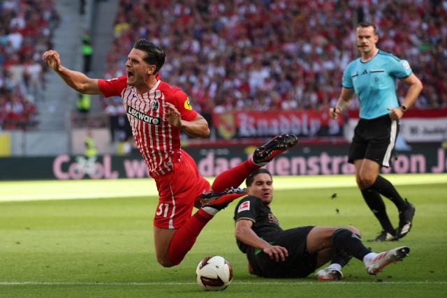 12 September 2026, Baden-Wuerttemberg, Freiburg im Breisgau: Moenchengladbach's Kevin Diks (C) fouls Freiburg's Igor Matanovic (L) during the German Bundesliga soccer match between SC Freiburg and Borussia Moenchengladbach at Europa-Park Stadium. Photo: Philipp von Ditfurth/dpa - WICHTIGER HINWEIS: Gemäß den Vorgaben der Bundesliga bzw. des DFB Deutscher Fußball-Bund ist es untersagt, in dem Stadion und/oder vom Spiel angefertigte Fotoaufnahmen in Form von Sequenzbildern und/oder videoähnlichen Fotostrecken zu verwerten bzw. verwerten zu lassen.